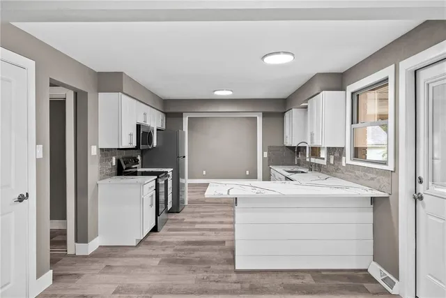 a large white kitchen with kitchen island