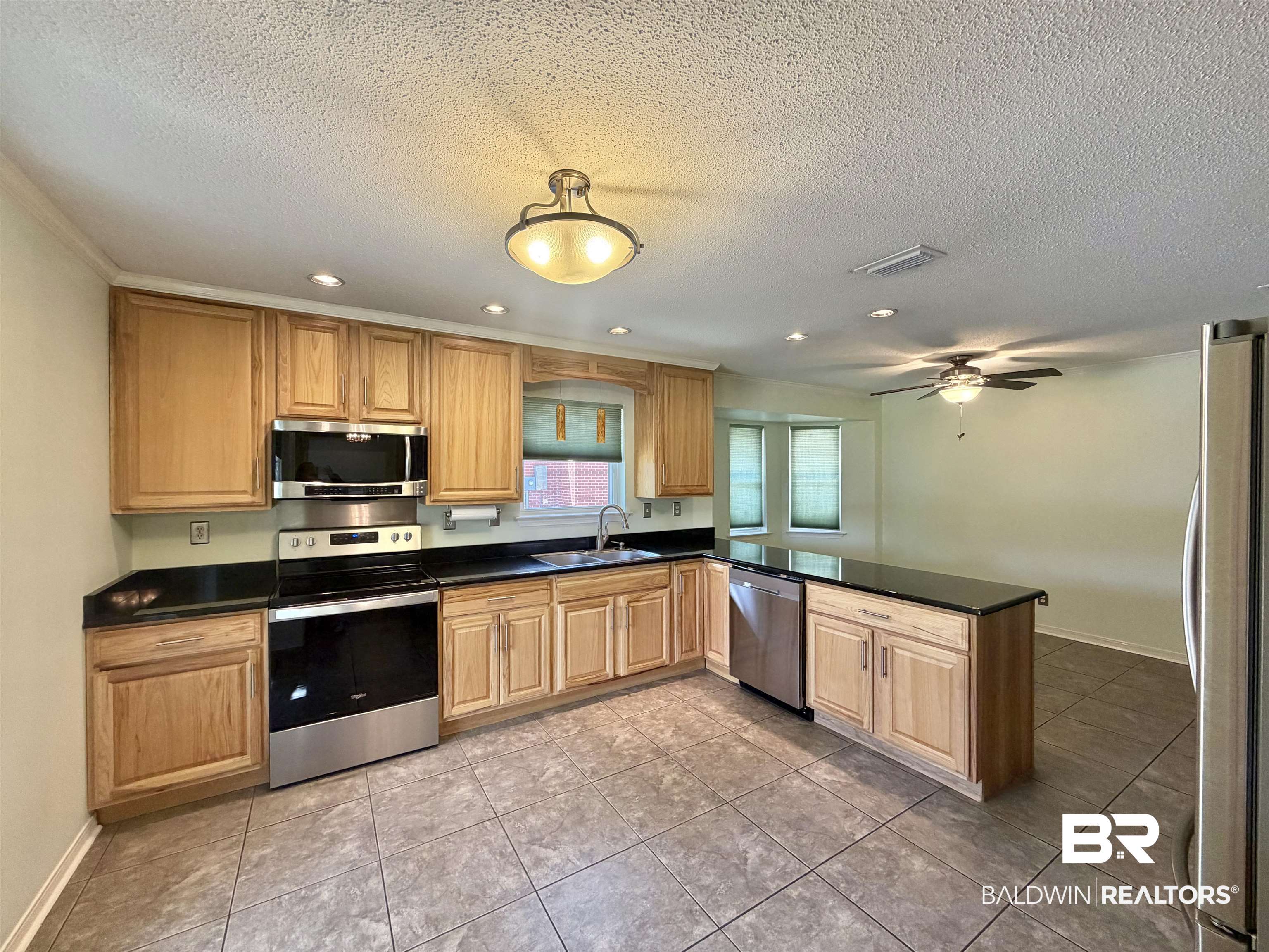 7310 Cheryl Court Mobile, AL 36695 - Photo 8 of 23 Kitchen featuring stainless steel appliances, dark countertops, a peninsula, recessed lighting, and light tile patterned floors