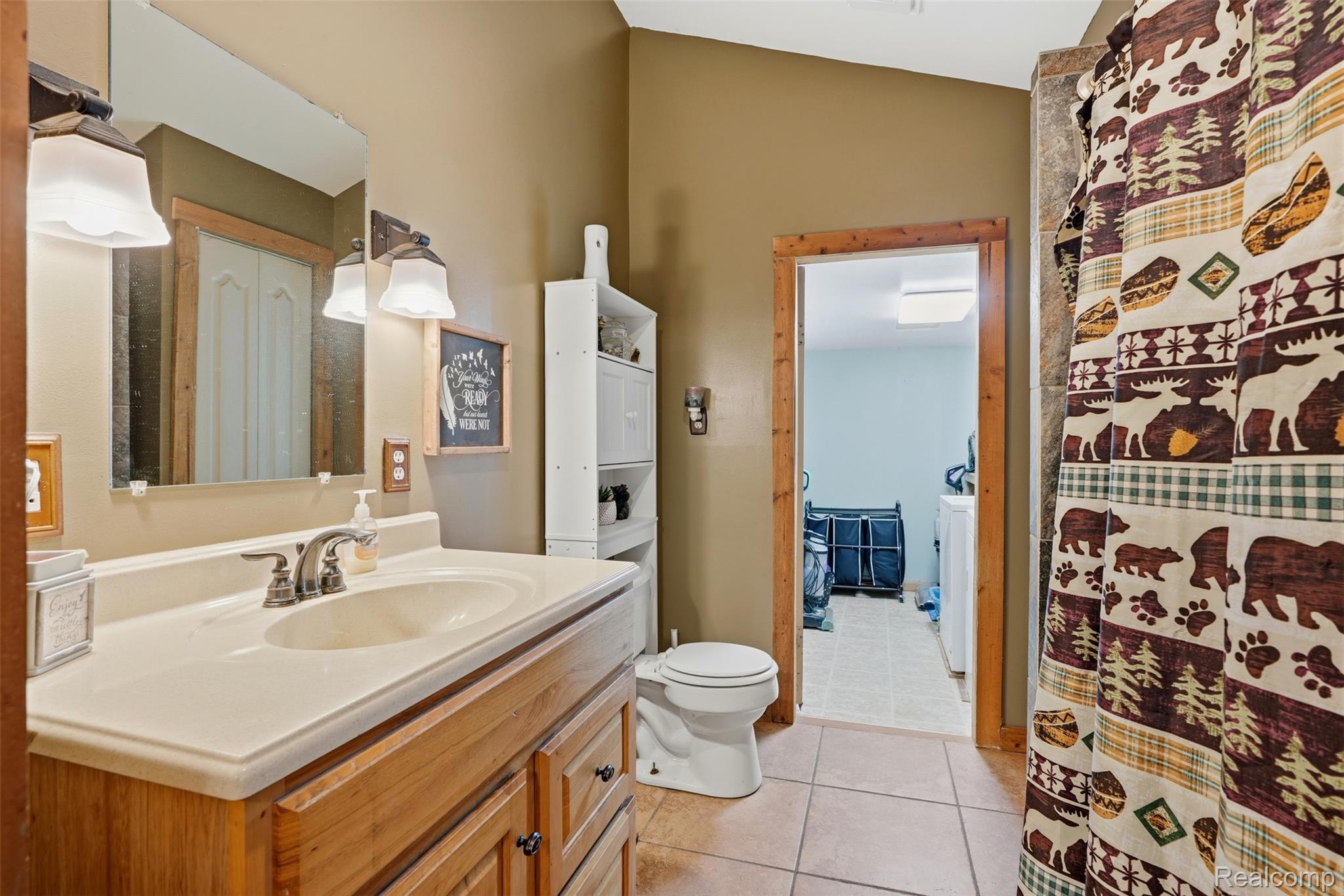 8732 Kinch Road Jackson, MI 49201 - Photo 18 of 39 Full bath featuring vanity, a shower with curtain, and light tile patterned floors