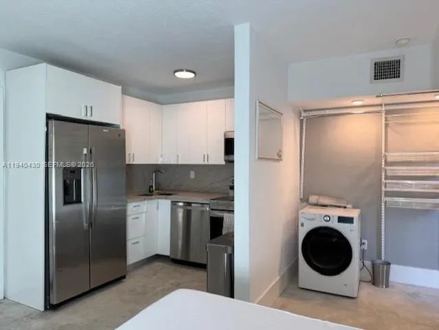 a kitchen with stainless steel appliances granite countertop a refrigerator and a sink