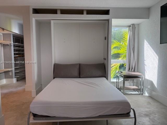 150 Southwest 10th Street, Unit 7 Miami, FL 33130 - Photo 4 of 15 a large bed sitting in a bedroom next to a window