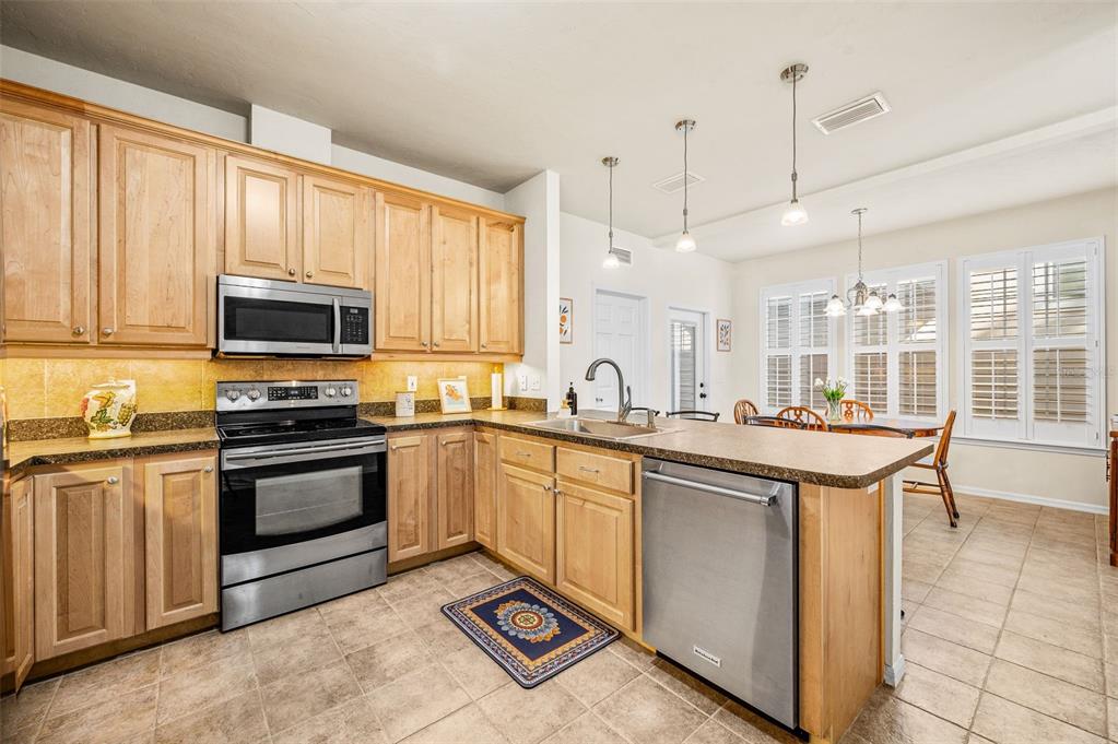 11550 Northwest 17 Place Gainesville, FL 32606 - Photo 11 of 48 a kitchen with stainless steel appliances granite countertop a stove a sink and a microwave