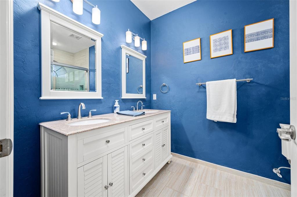 11550 Northwest 17 Place Gainesville, FL 32606 - Photo 20 of 48 a bathroom with a double vanity sink a mirror and a bathtub