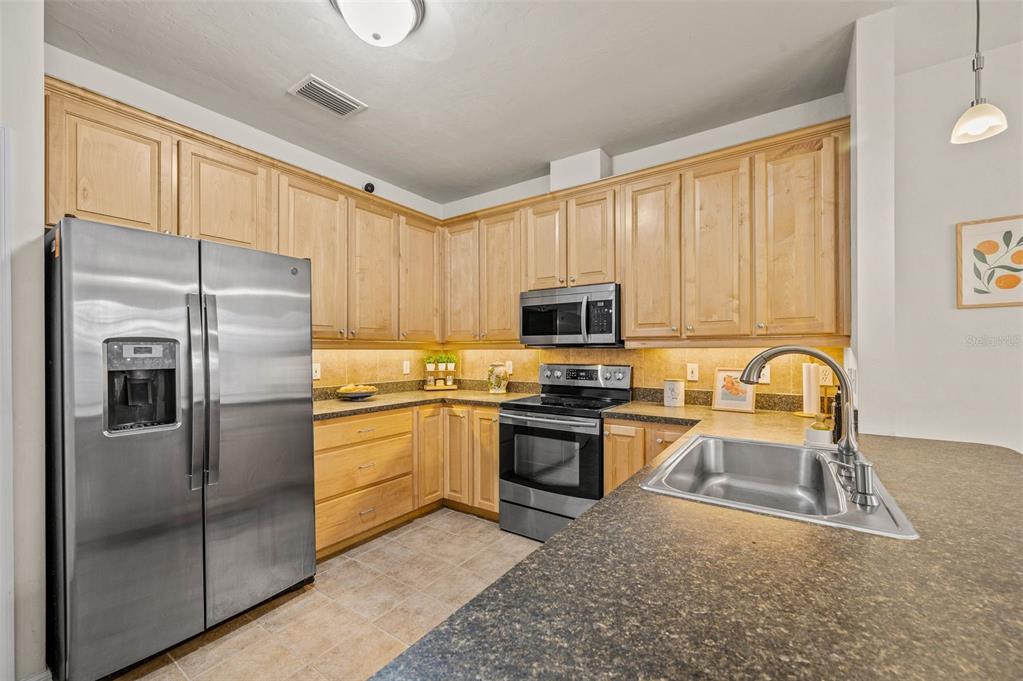 11550 Northwest 17 Place Gainesville, FL 32606 - Photo 9 of 48 a kitchen with stainless steel appliances granite countertop a refrigerator a stove top oven a sink and dishwasher