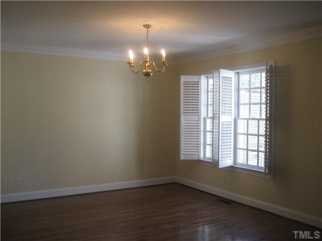 1409 Canfield Court Raleigh, NC 27608 - Photo 3 of 9 an empty room with wooden floor and windows