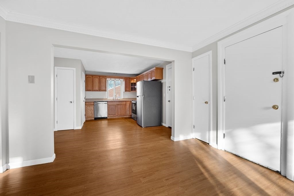 133 Winthrop Street, Unit 21 Framingham, MA 01702 - Photo 11 of 15 a view of empty room with wooden floor and kitchen