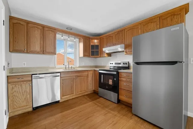 a kitchen with granite countertop a refrigerator stove top oven and sink