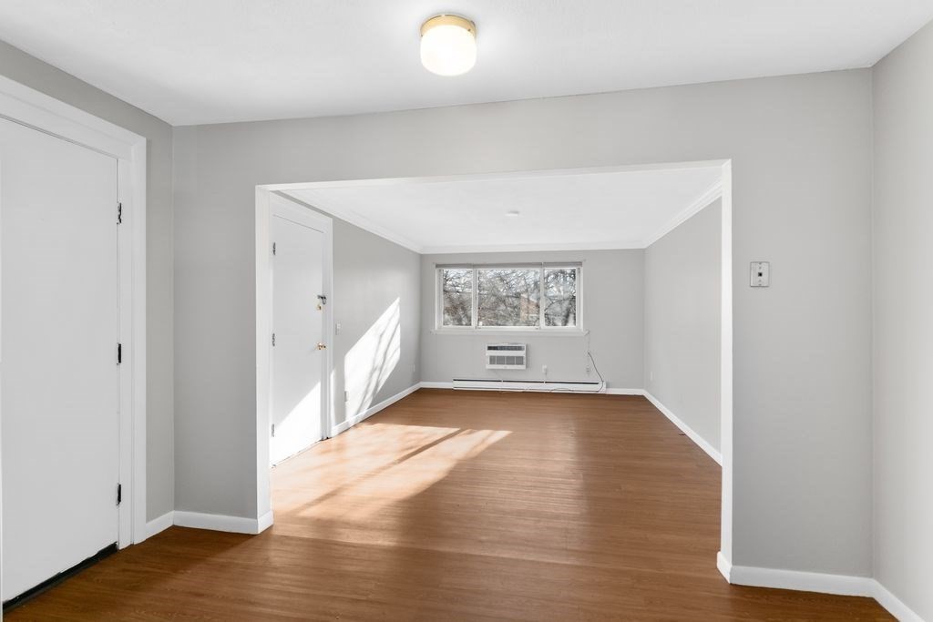 133 Winthrop Street, Unit 21 Framingham, MA 01702 - Photo 2 of 15 a view of an empty room with wooden floor and a window