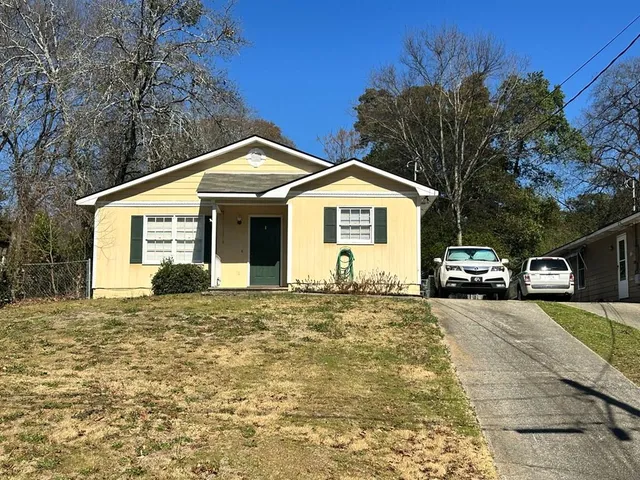 a front view of a house with a garden and yard