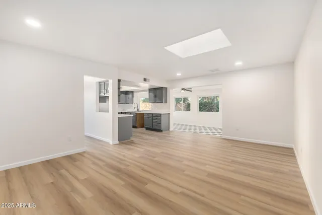a view of empty room with kitchen and window