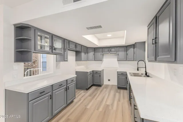 a large kitchen with a lot of counter space and wooden floor