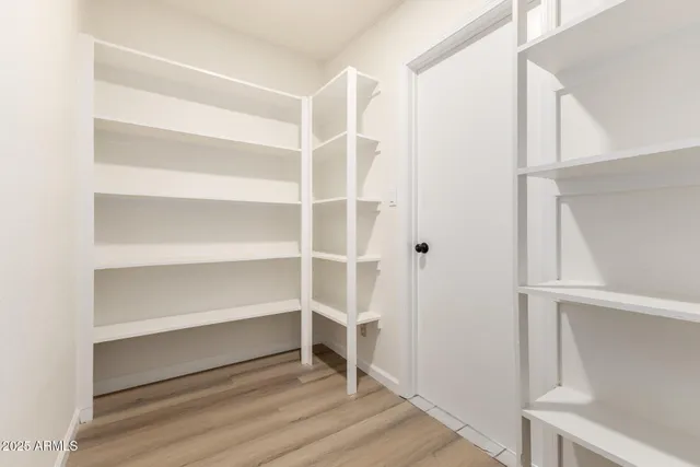a view of walk in closet with empty racks