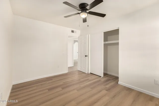 a view of a livingroom with wooden floor and a ceiling fan