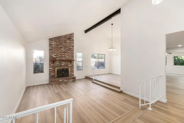 a view of a livingroom with wooden floor and a fireplace