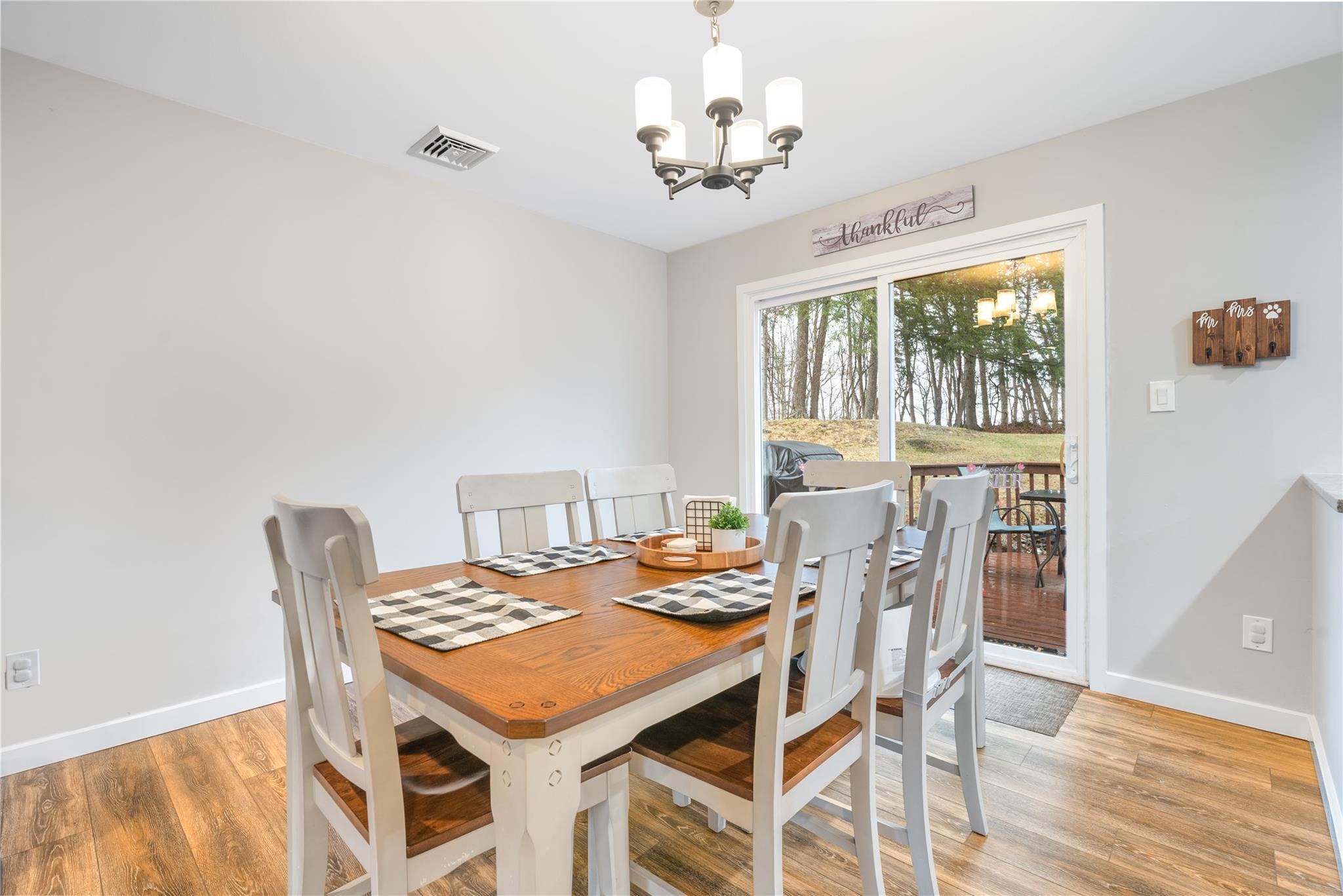 45 Raker Road Poughkeepsie, NY 12603 - Photo 7 of 25 Dining room with baseboards, visible vents, wood finished floors, and a chandelier