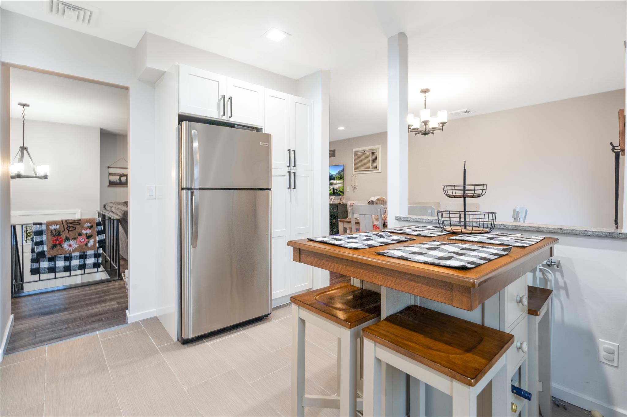 45 Raker Road Poughkeepsie, NY 12603 - Photo 10 of 25 Kitchen featuring hanging light fixtures, visible vents, freestanding refrigerator, white cabinets, and a notable chandelier