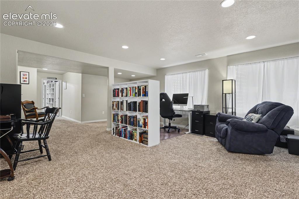 6598 Alliance Loop Colorado Springs, CO 80925 - Photo 30 of 39 Carpeted interior space featuring recessed lighting and multiple windows with white curtains
