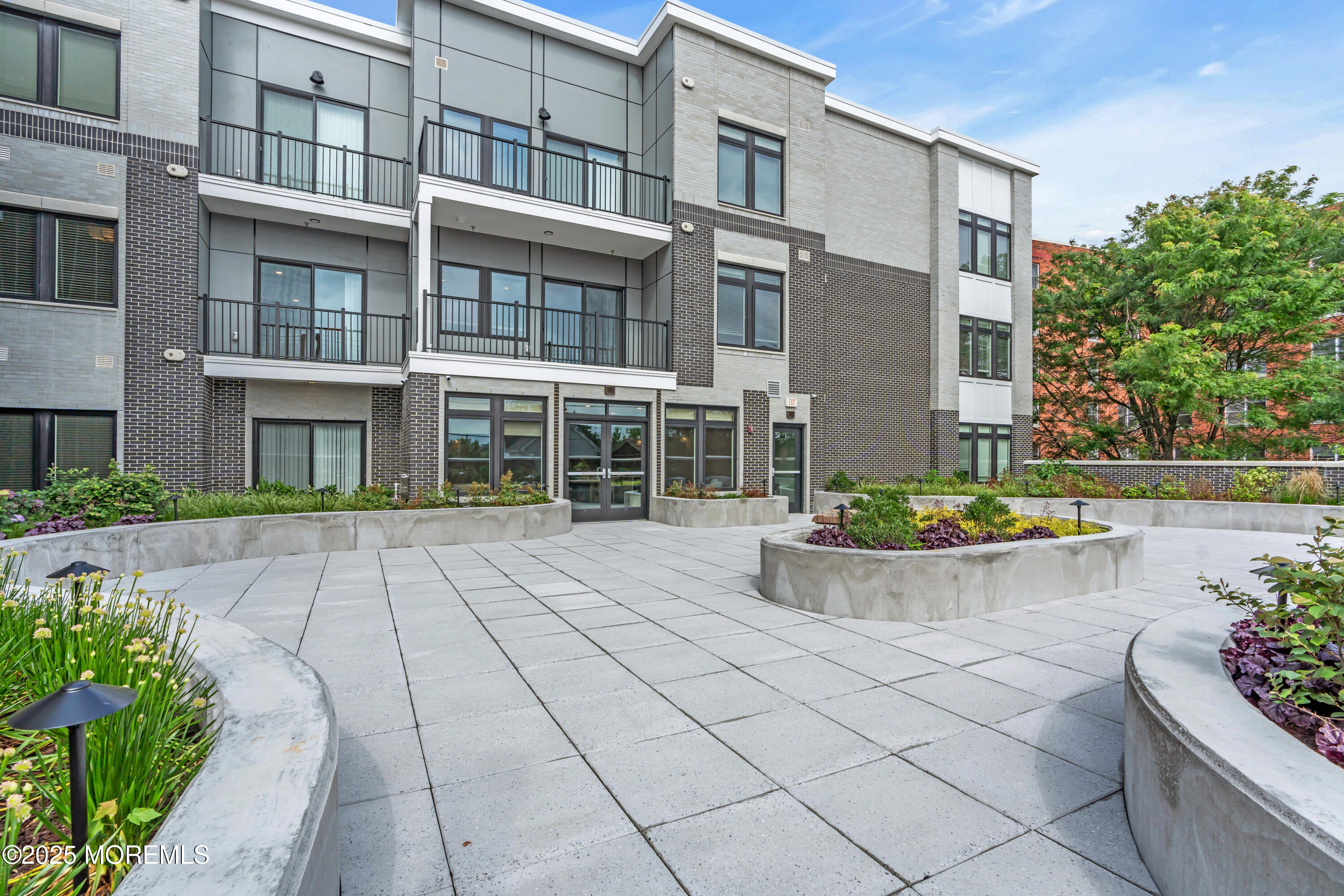 120 Monmouth Street, Unit 302 Red Bank, NJ 07701 - Photo 26 of 37 a view of a white building among the flower plants