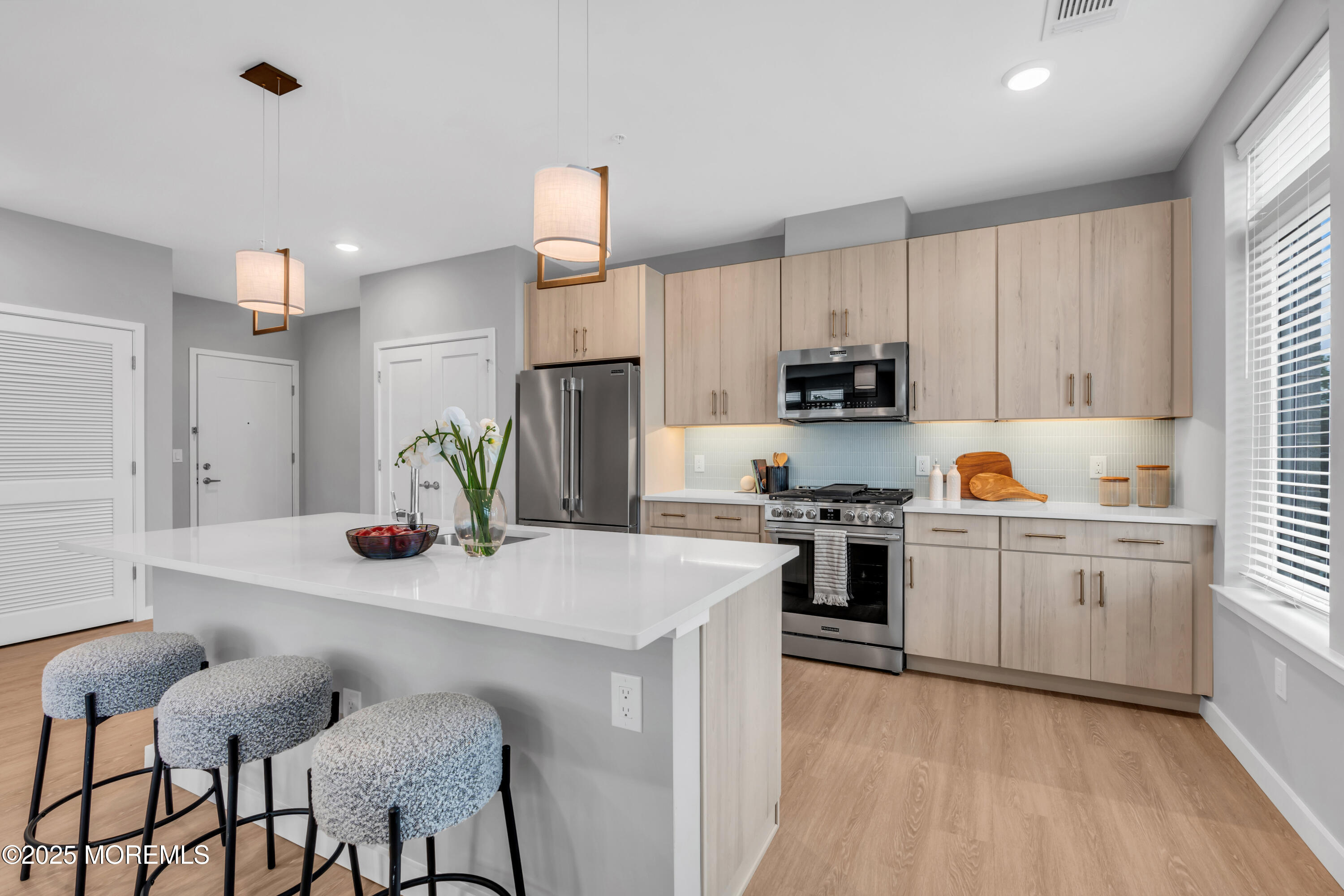120 Monmouth Street, Unit 302 Red Bank, NJ 07701 - Photo 6 of 37 a kitchen with granite countertop white cabinets and stainless steel appliances