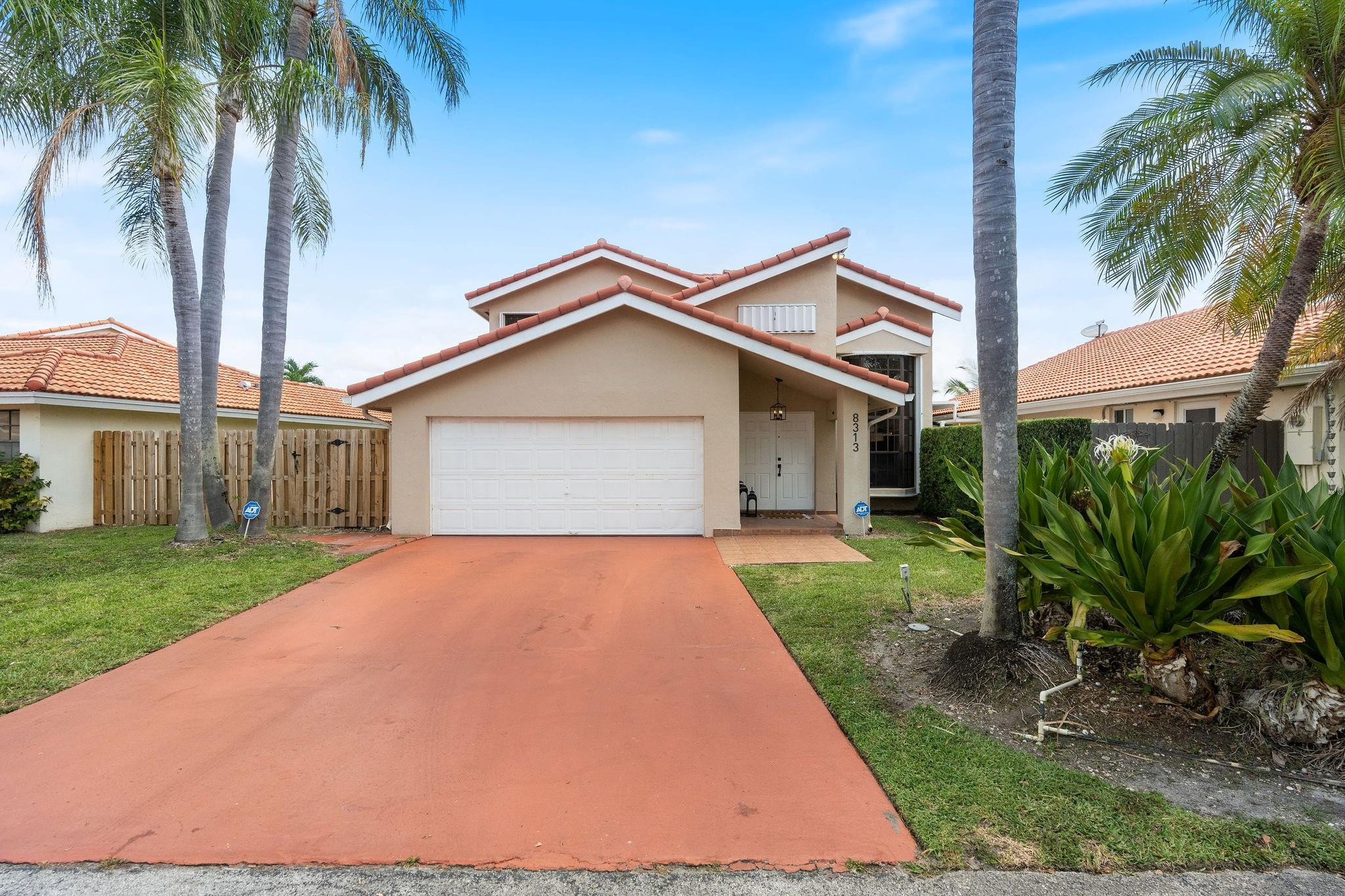 8313 Northwest 188th Terrace Hialeah, FL 33015 - Photo 2 of 50 a front view of a house with a yard and garage