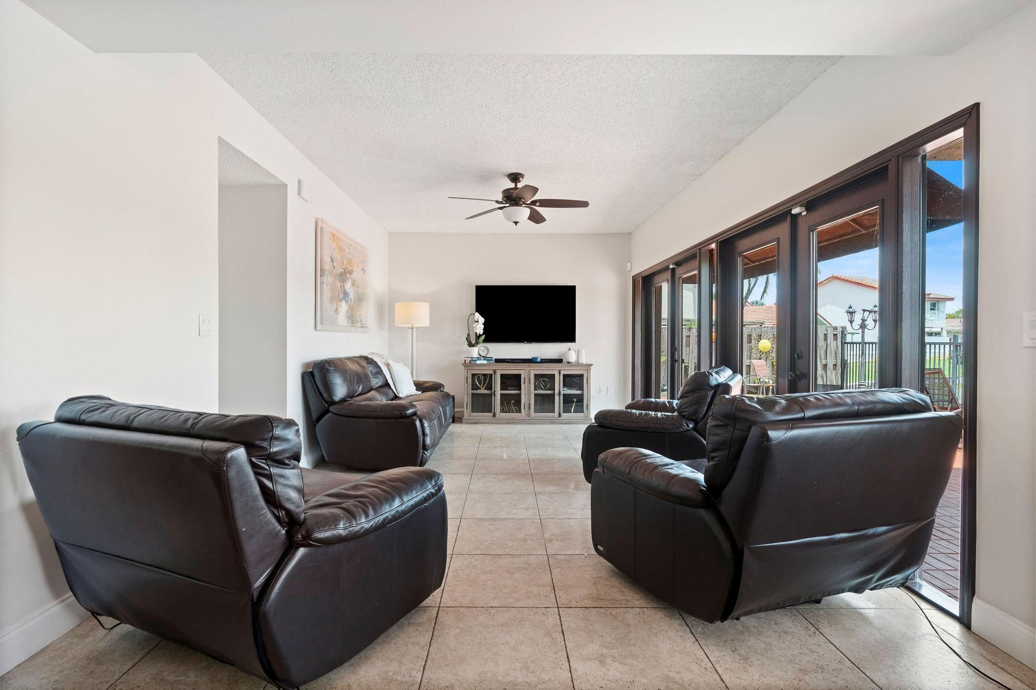 8313 Northwest 188th Terrace Hialeah, FL 33015 - Photo 22 of 50 a living room with furniture a flat screen tv and a large window