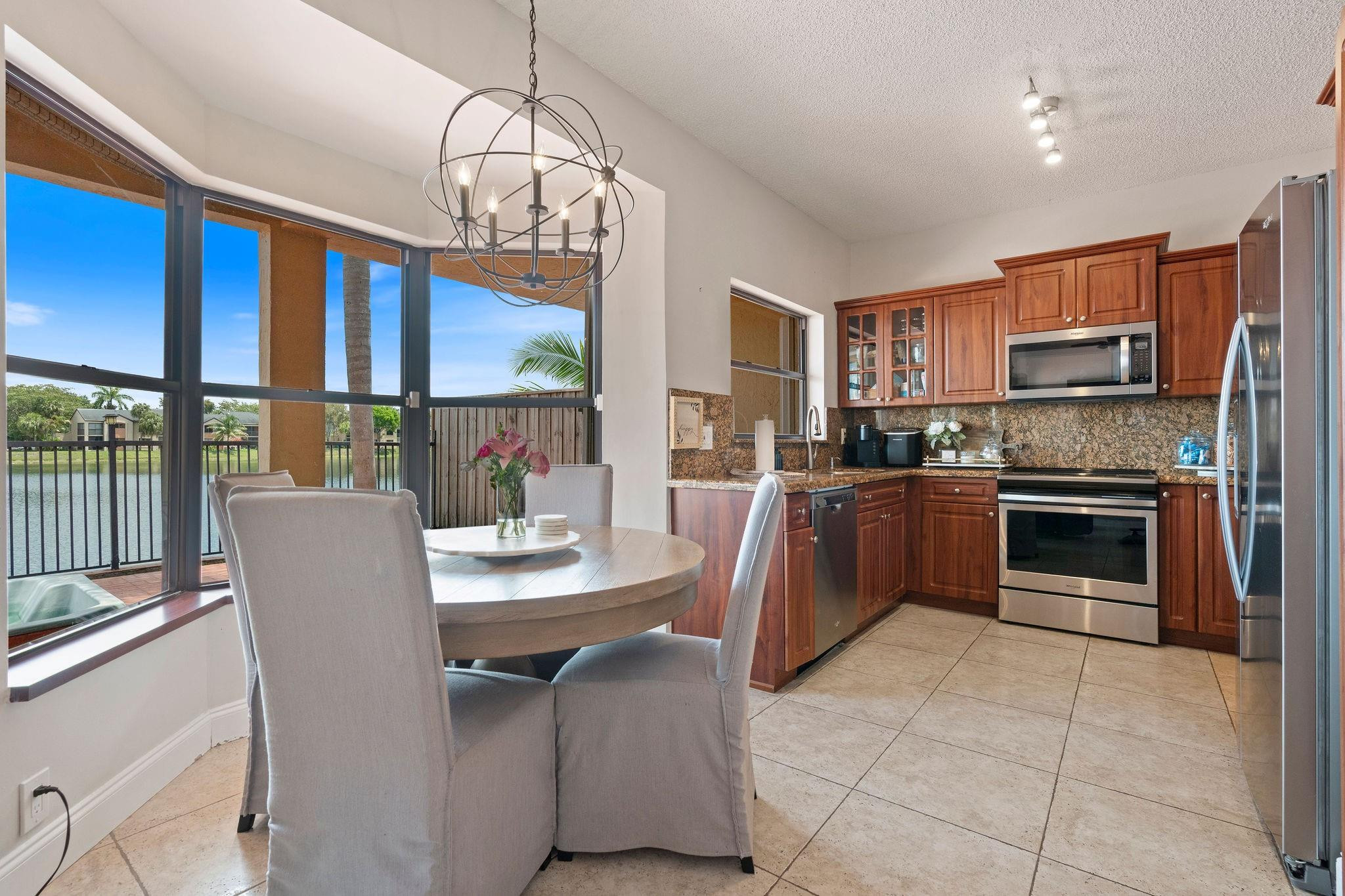 8313 Northwest 188th Terrace Hialeah, FL 33015 - Photo 26 of 50 a kitchen with a table chairs microwave and refrigerator