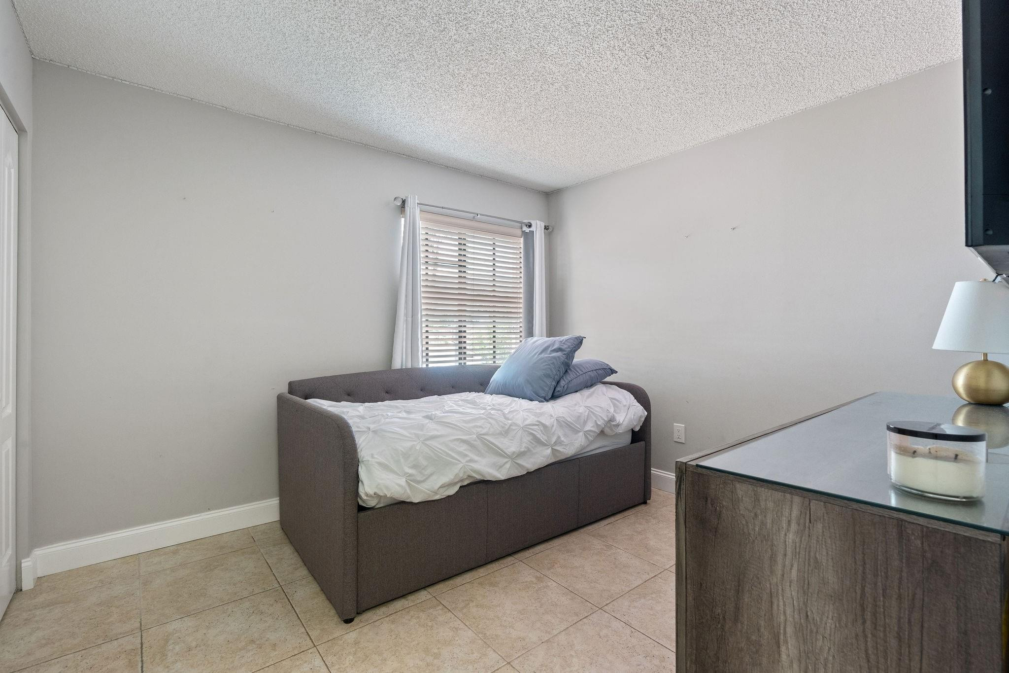 8313 Northwest 188th Terrace Hialeah, FL 33015 - Photo 35 of 50 a bedroom with a bed and window