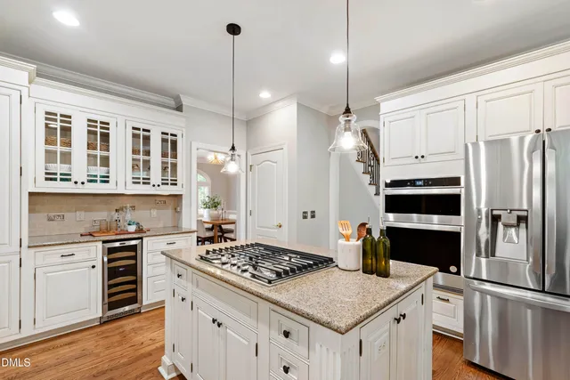 a kitchen with a stove a sink a center island and windows