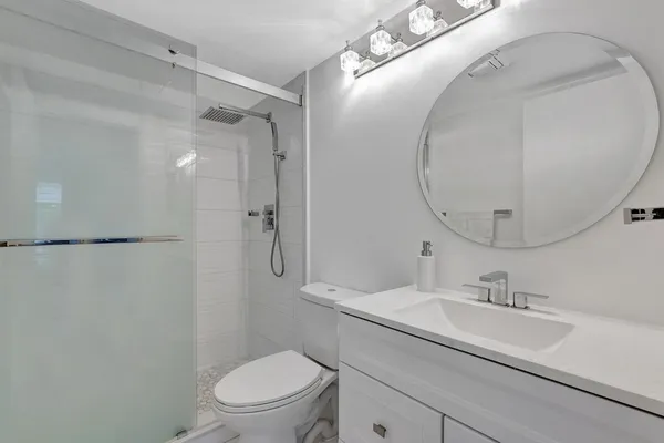 a bathroom with a granite countertop sink toilet and shower