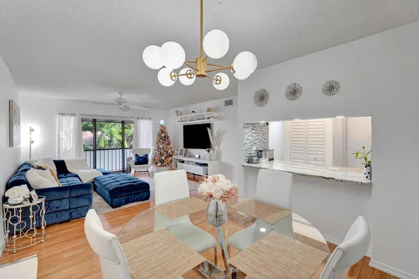 a living room with couches a dining table and chairs with wooden floor