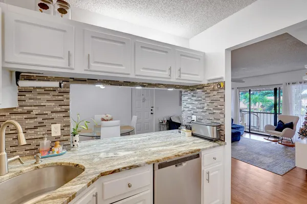 a kitchen with granite countertop a sink and a stove