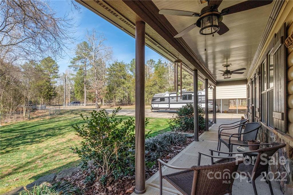 9915 Mini Ranch Road Waxhaw, NC 28173 - Photo 3 of 33 a view of a patio with table and chairs potted plants and floor to ceiling window
