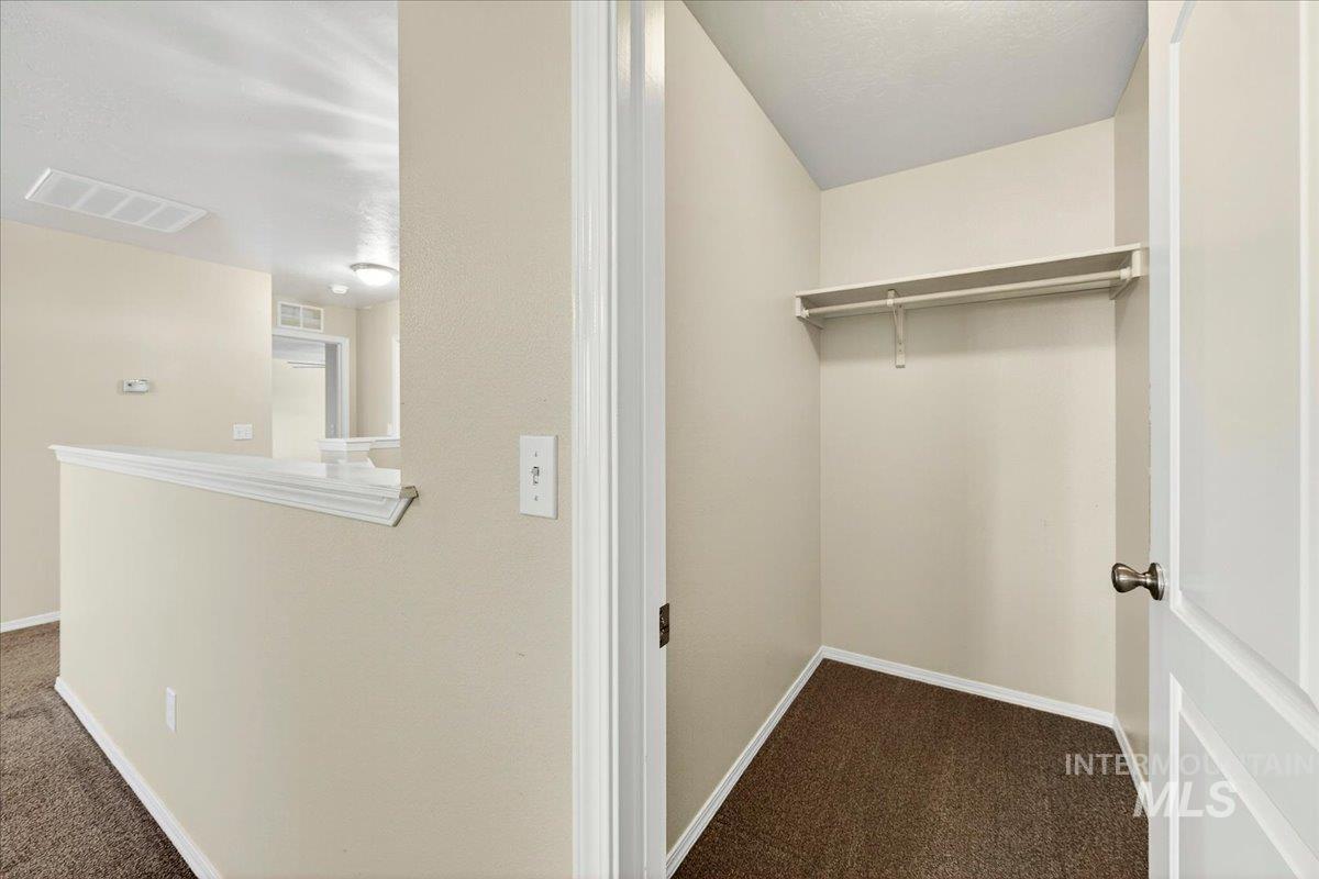 1555 Condor Drive Middleton, ID 83644 - Photo 36 of 50 Closet featuring a built-in shelf and hanging rod, neutral wall paint, and dark carpet flooring
