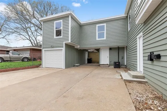 a view of a house with a yard and potted plants