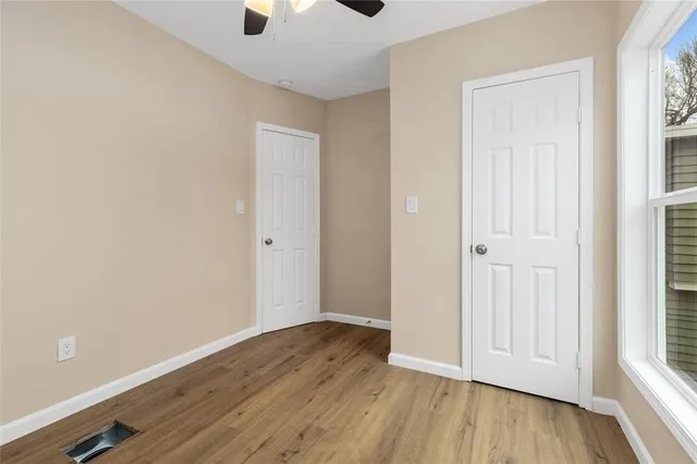 an empty room with wooden floor and windows