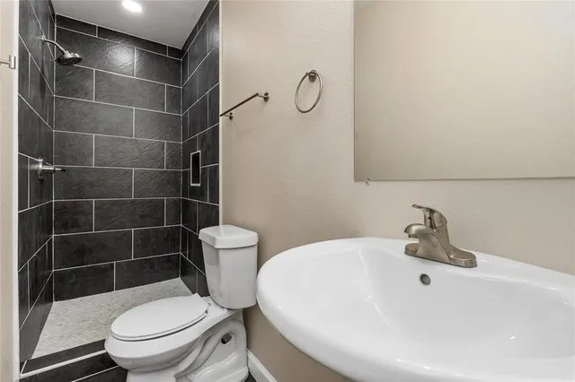 a white toilet sitting next to a bathroom sink