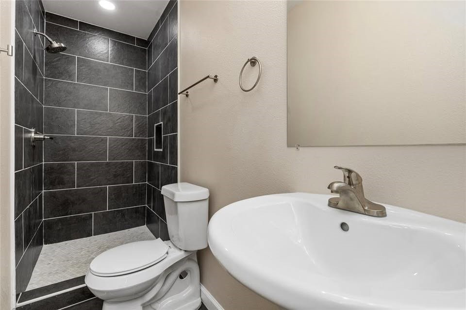 702 East Main Street Brenham, TX 77833 - Photo 7 of 7 a white toilet sitting next to a bathroom sink