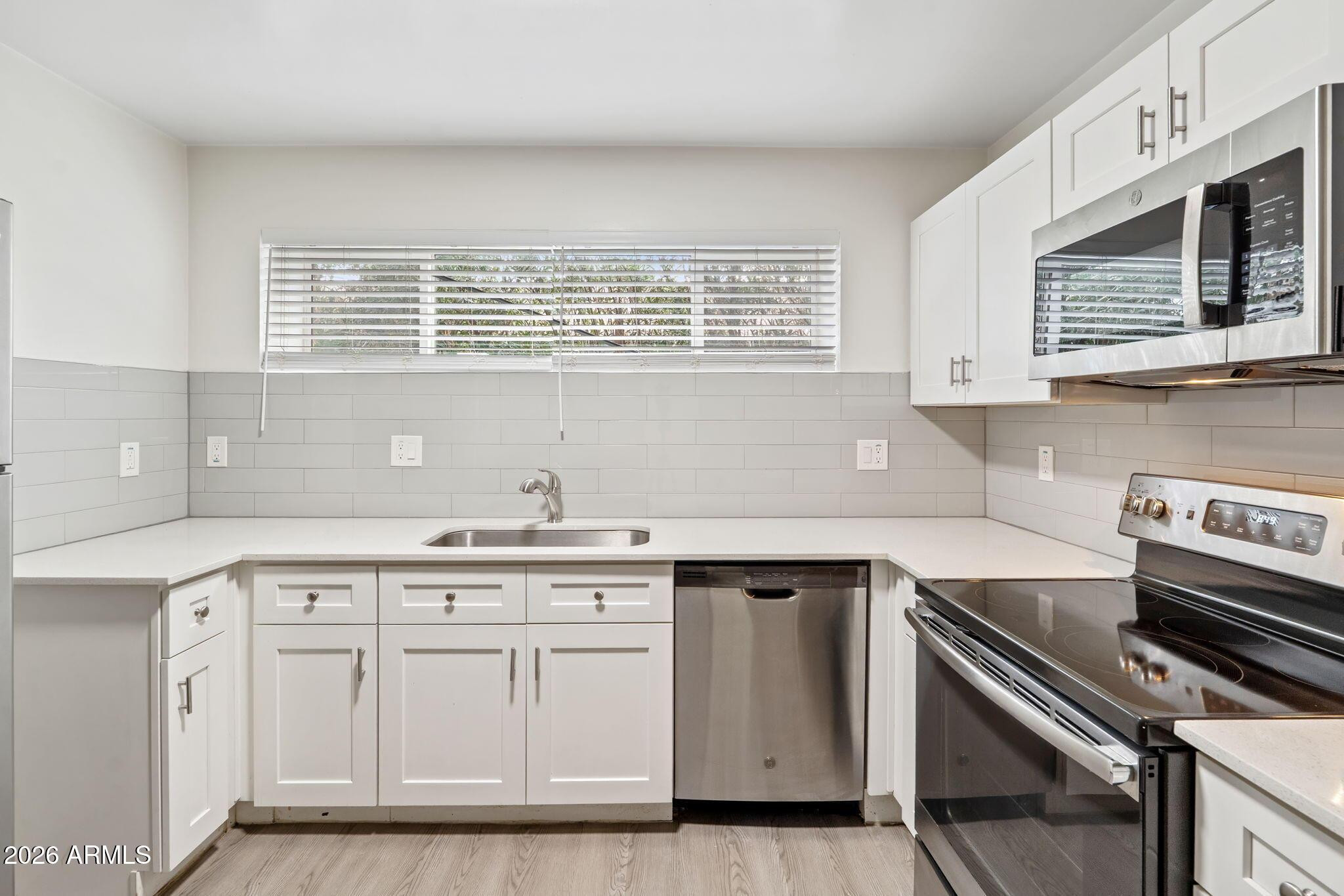 a kitchen with cabinets appliances and a sink