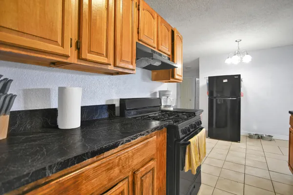 a kitchen with granite countertop a stove and a refrigerator