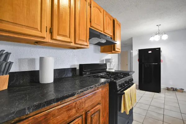 a kitchen with stainless steel appliances granite countertop a stove a refrigerator and a microwave