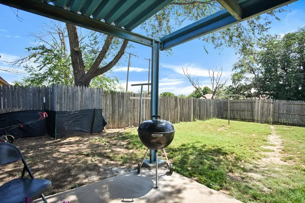 a view of a backyard with table and chairs and potted plants