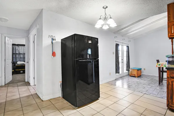 a view of a hallway with dining area and chandelier
