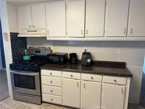 a kitchen with white cabinets and appliances