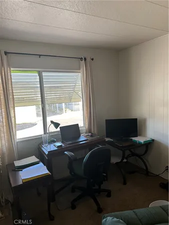 a view of a workspace with furniture and a window