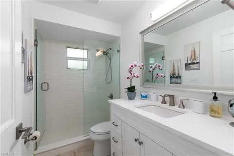 a bathroom with a granite countertop sink toilet and shower