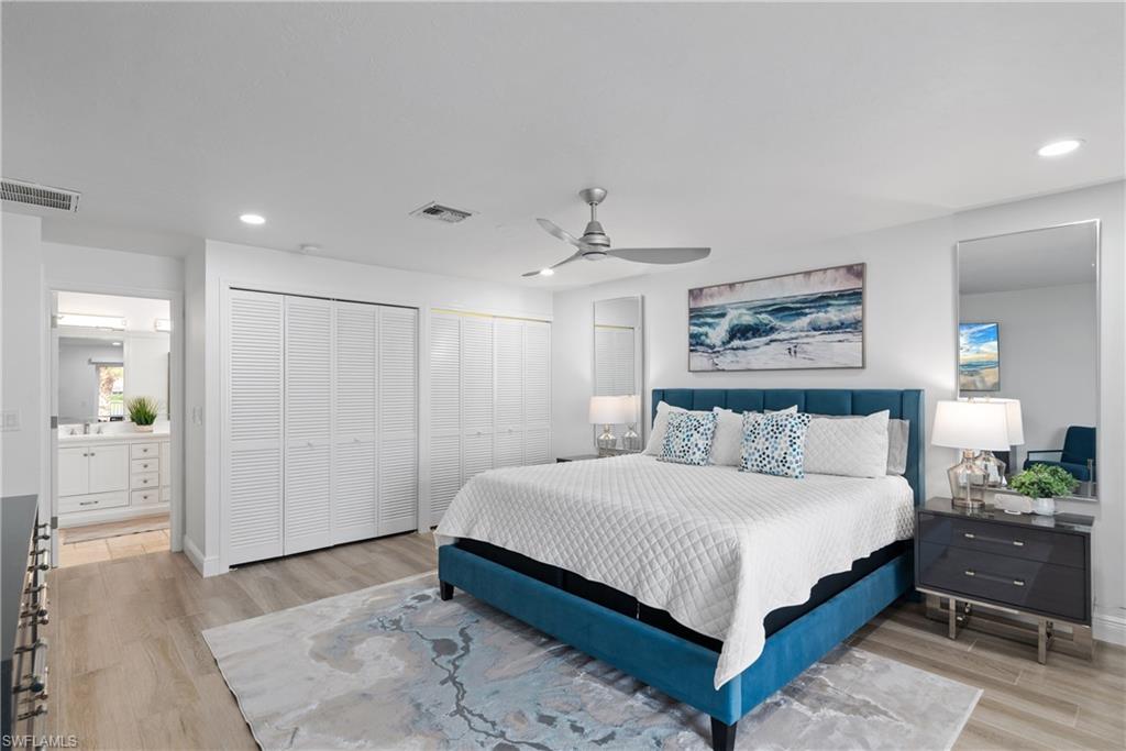 2500 Kings Lake Boulevard Naples, FL 34112 - Photo 20 of 31 a bedroom with a large bed and a chandelier