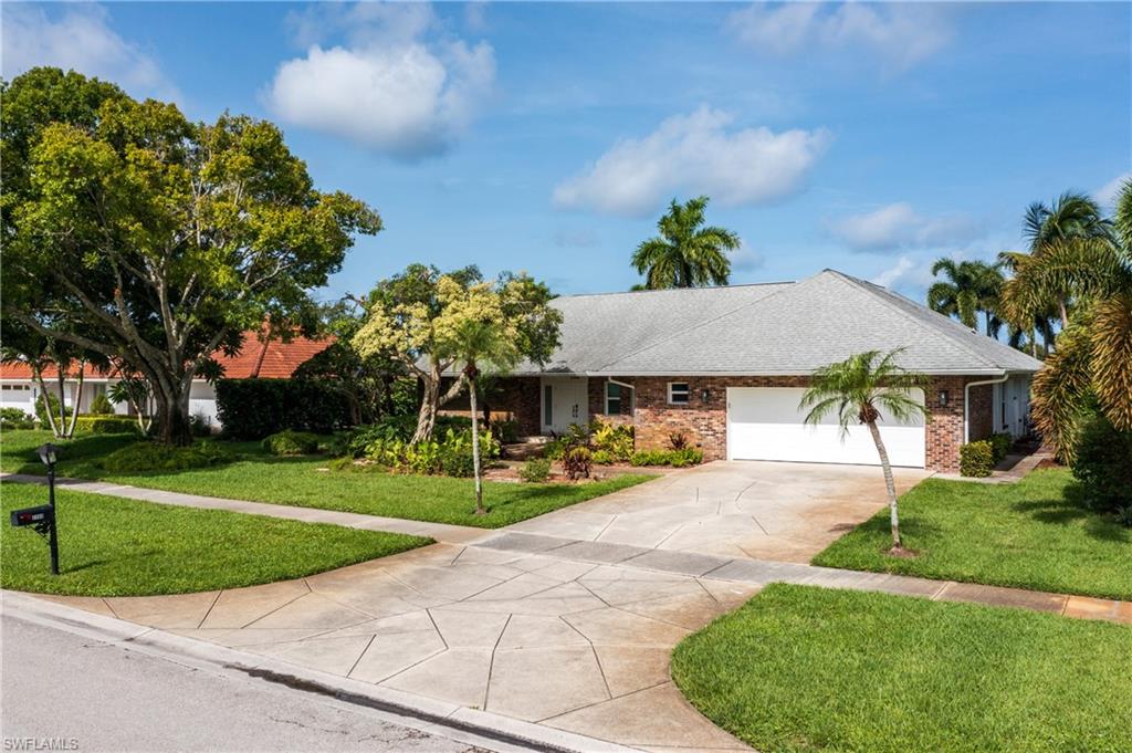 2500 Kings Lake Boulevard Naples, FL 34112 - Photo 2 of 31 a house view with a garden space