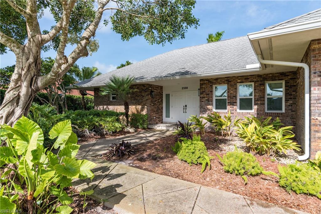 2500 Kings Lake Boulevard Naples, FL 34112 - Photo 3 of 31 a front view of a house with garden