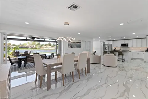 a dining room with furniture and a floor to ceiling window