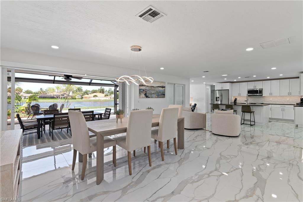 2500 Kings Lake Boulevard Naples, FL 34112 - Photo 4 of 31 a dining room with furniture and a floor to ceiling window